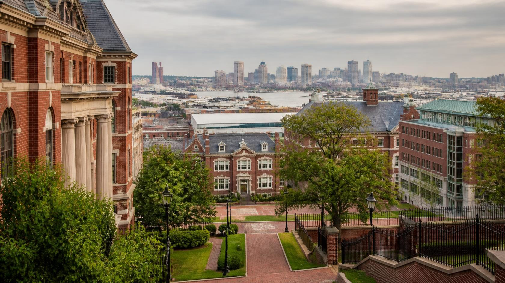 Baltimore brick campus greens and soft harbor skyline illustrating Johns Hopkins ABSN prerequisites for MSN Entry into Nursing planning